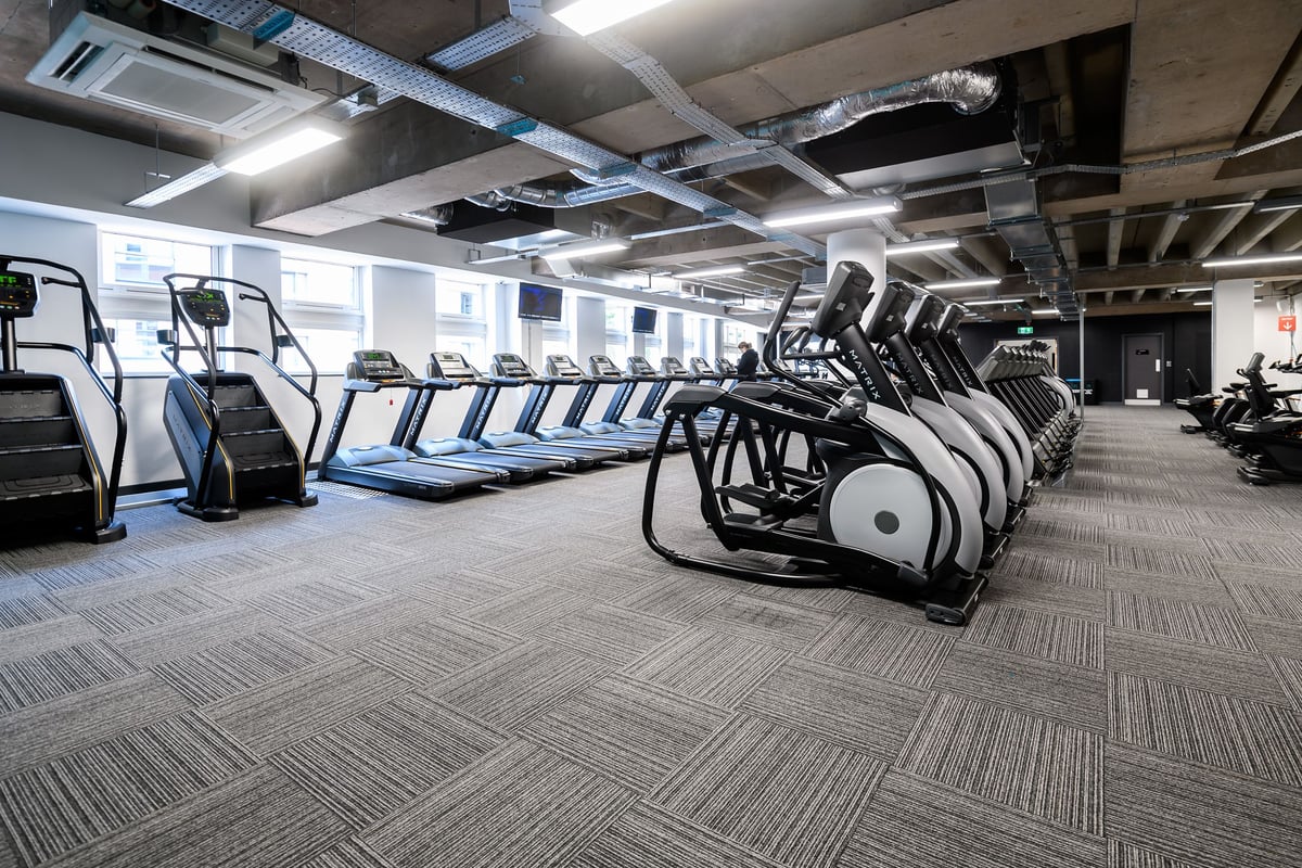 PureGym Birmingham Arcadian Centre: Rows of treadmills, stationary bikes, and other cardio machines in a modern gym setting.