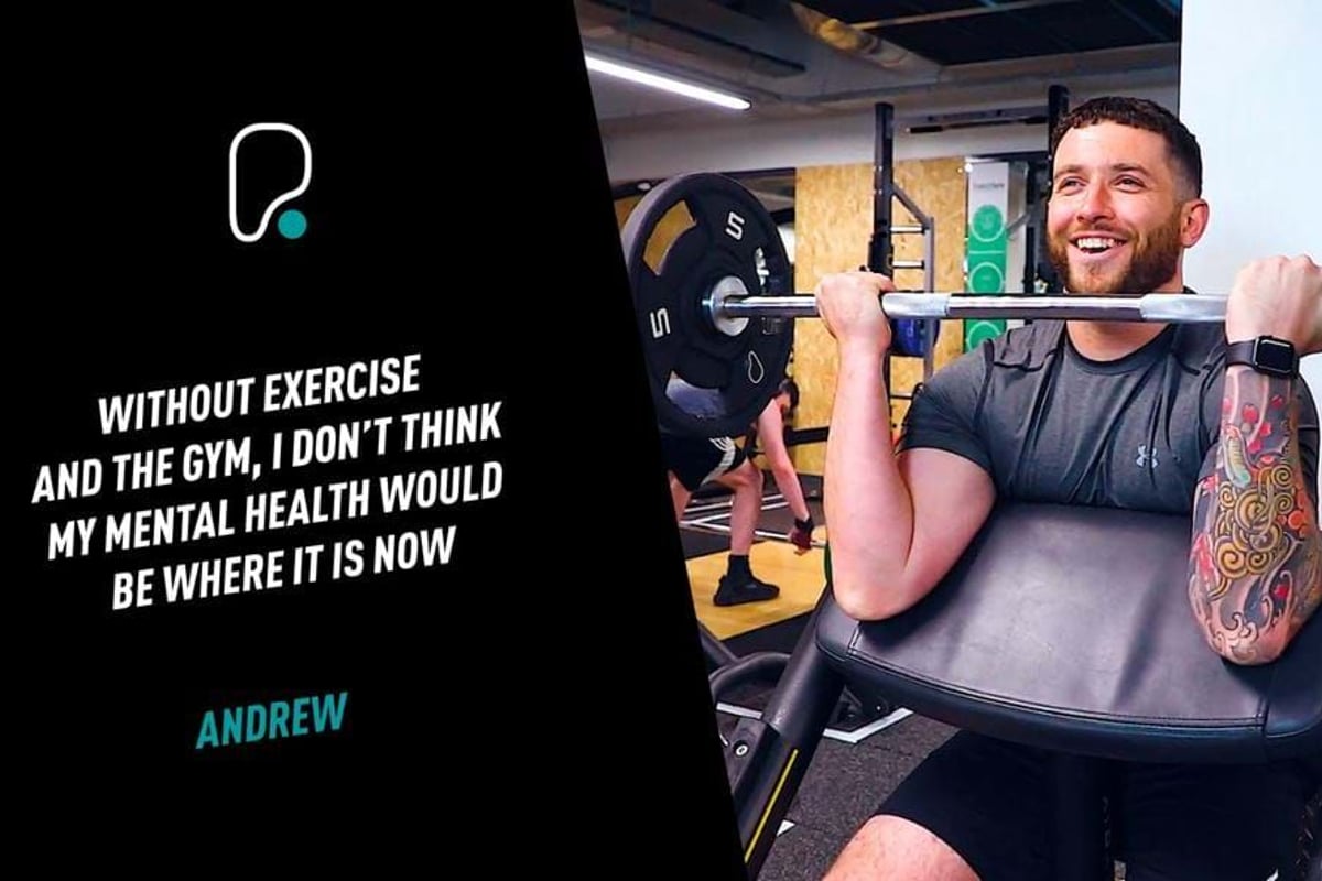 Man with tattoo lifting weights on preacher curl bench in gym smiling