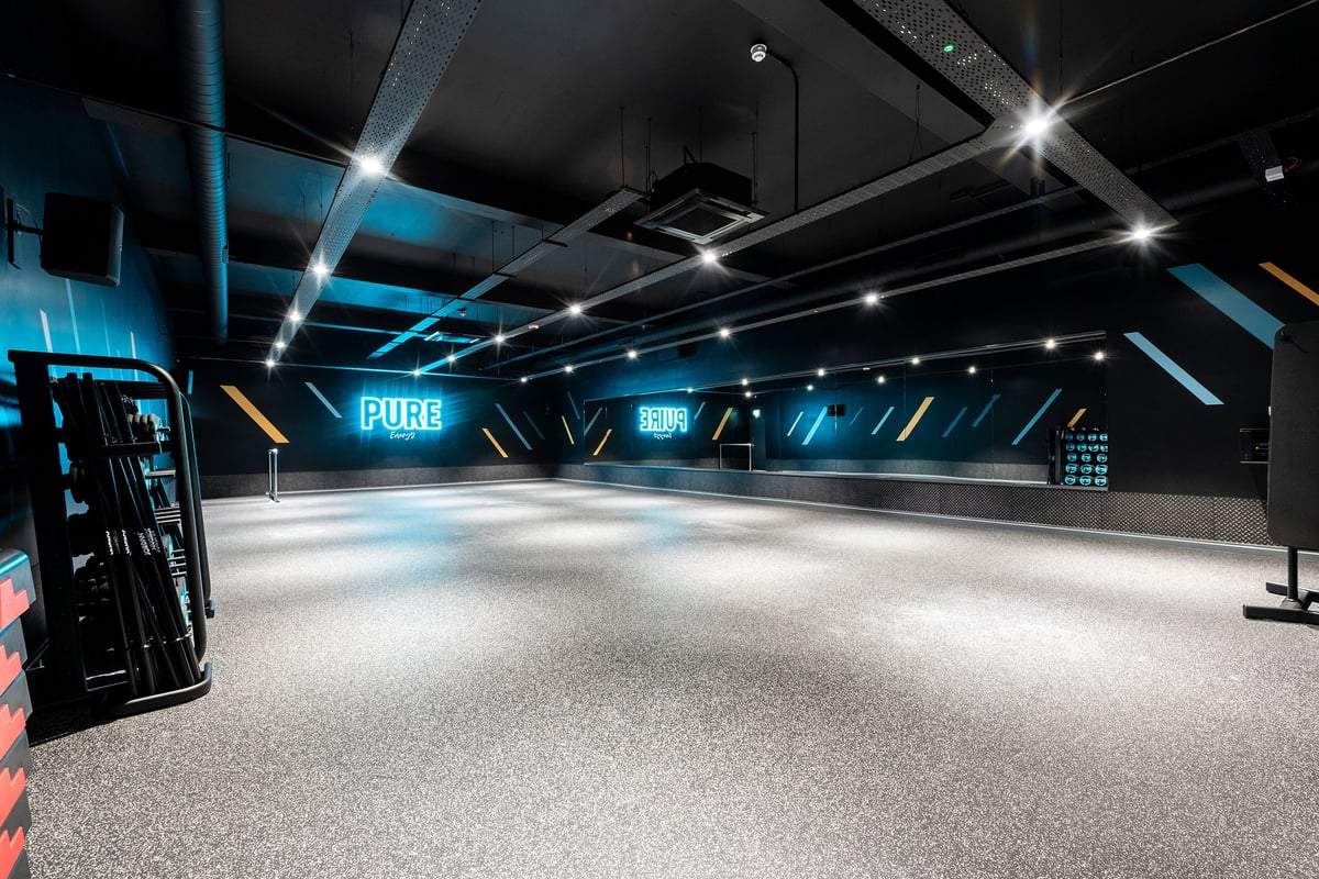 PureGym Edinburgh Craigleith Retail Park: Futuristic studio with spotlights, screens, rubberized flooring.