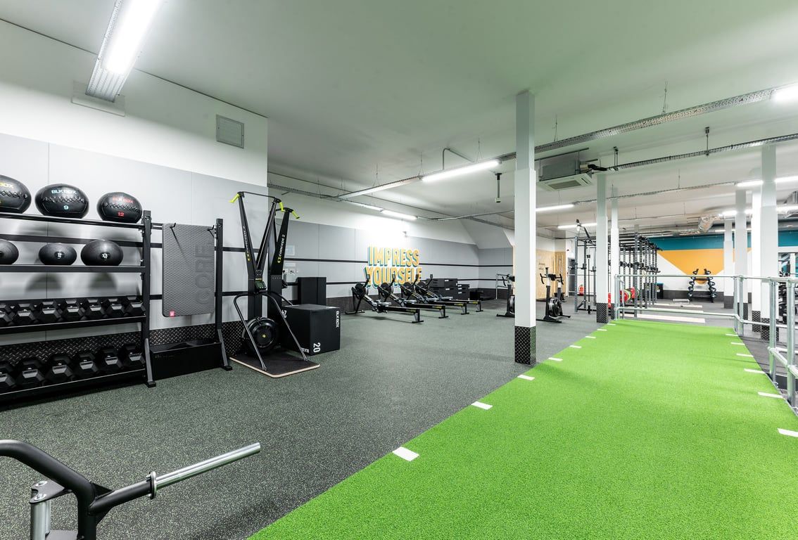 PureGym Solihull Sears Retail Park: Weight racks, medicine balls, squat racks, turf area, rubberized floor, gym equipment.