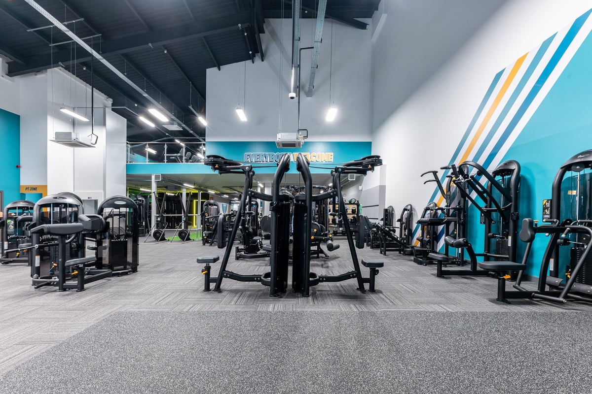 PureGym Redditch Ringway: Functional training area with cable machines, squat racks, weight plates, and rubberized flooring.