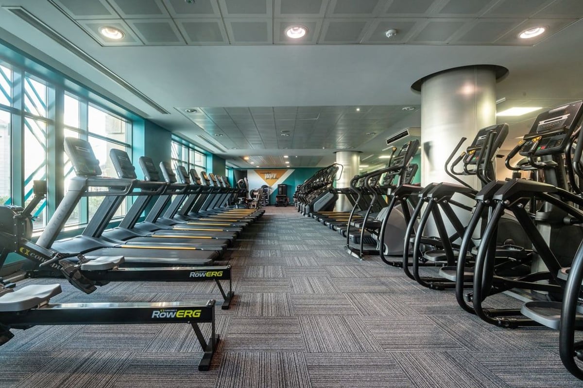 PureGym Edinburgh Exchange Crescent: Rows of treadmills and ellipticals in a bright fitness space with large windows.