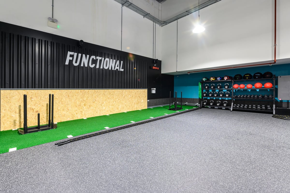 PureGym Northampton Weston Favell: Functional training area with green turf, free weights, rig, and rubberized flooring.
