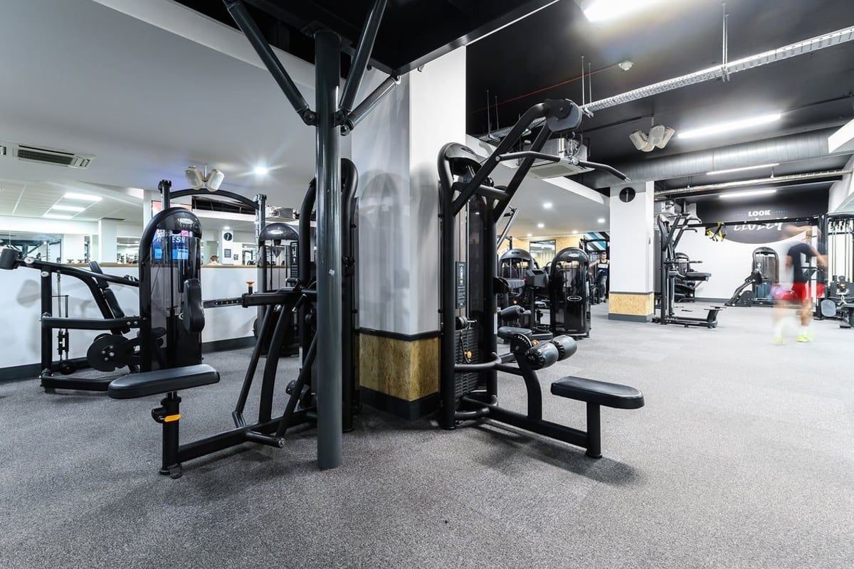 PureGym Oxford Central: Weight machines, benches, cable pulleys, and rubberized flooring in a well-equipped gym.
