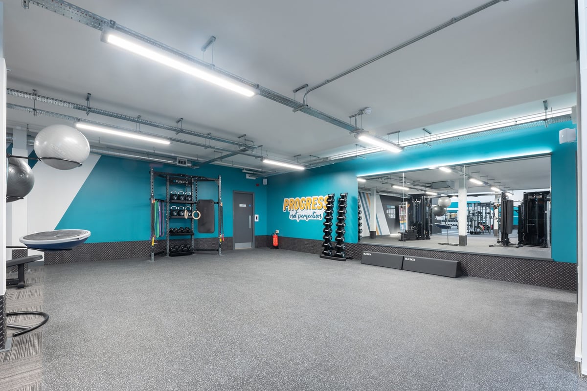PureGym Southport: Weight racks, resistance machines, free weights, rubberised flooring, and turquoise accent walls.