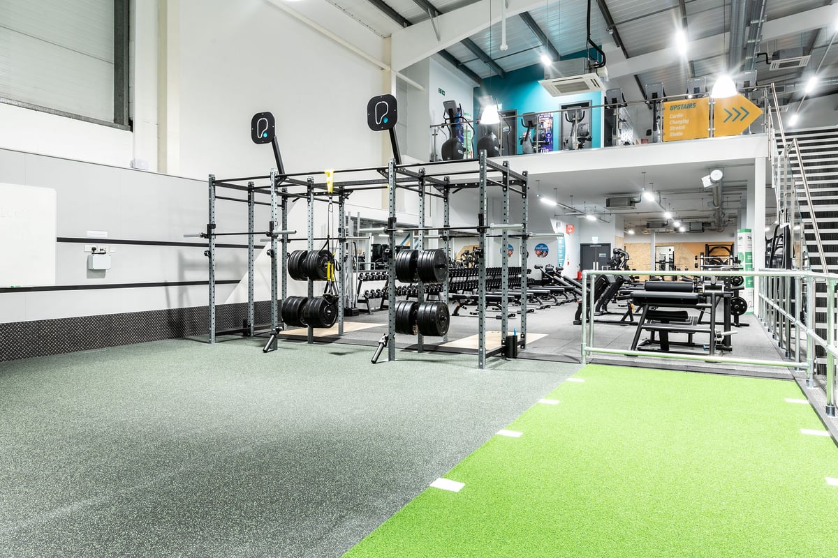 PureGym Torquay Bridge Retail Park: Racks with weight plates, benches, turf area, and rubberized flooring.