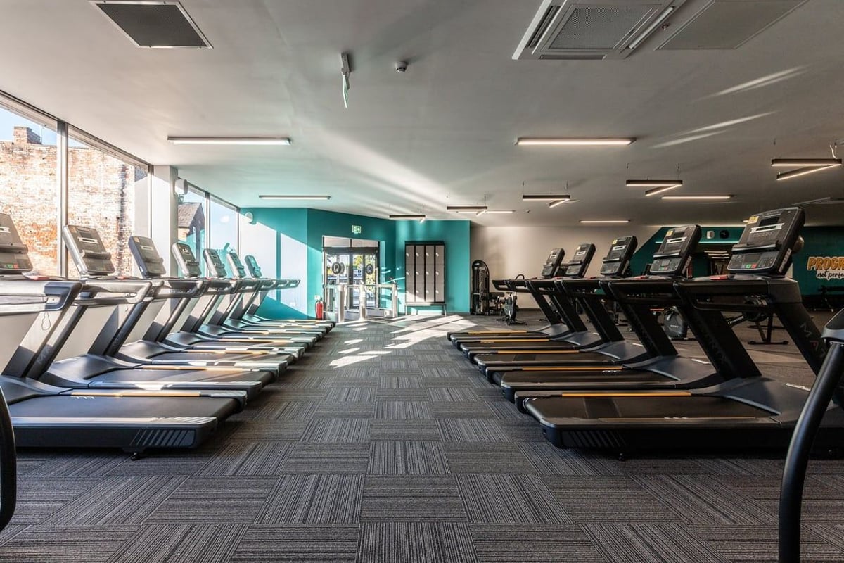 PureGym Tyldesley: Rows of treadmills, ellipticals, and other cardio machines in a bright gym studio.