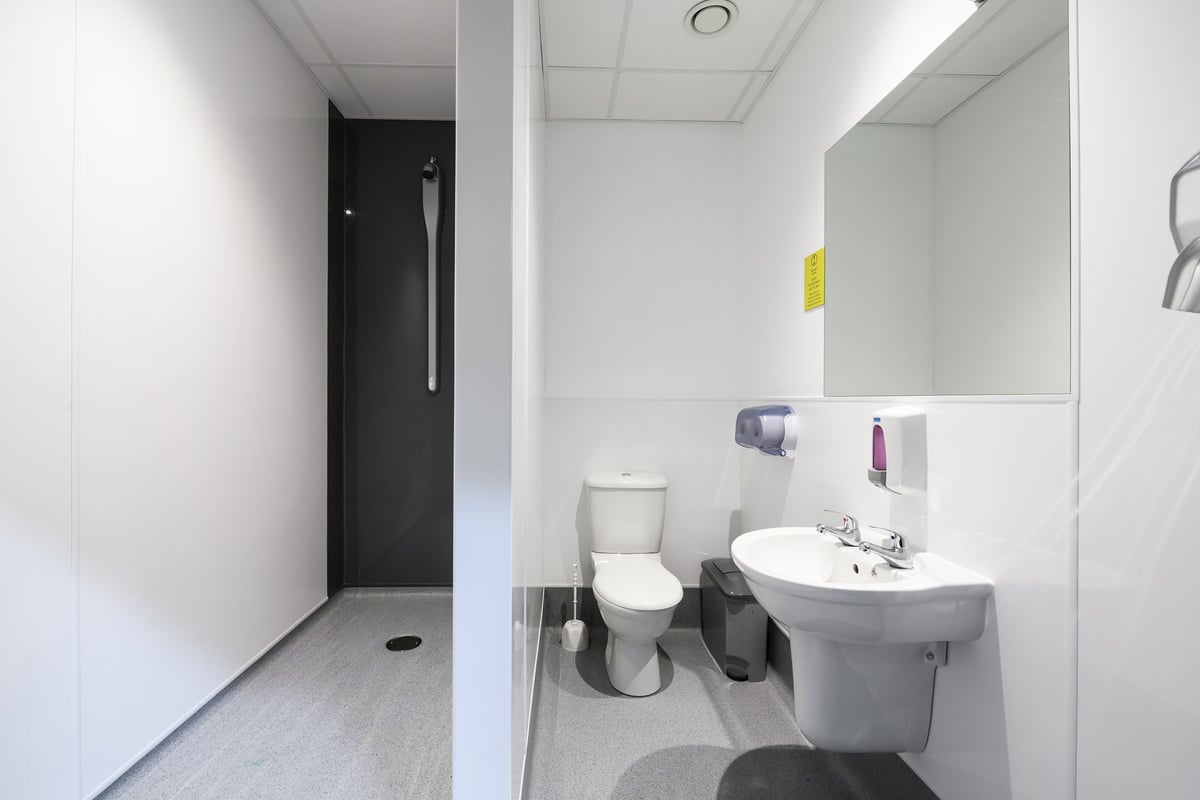 PureGym Buckingham: Toilet, sink, and bathroom accessories in a minimalistic commercial restroom setting.