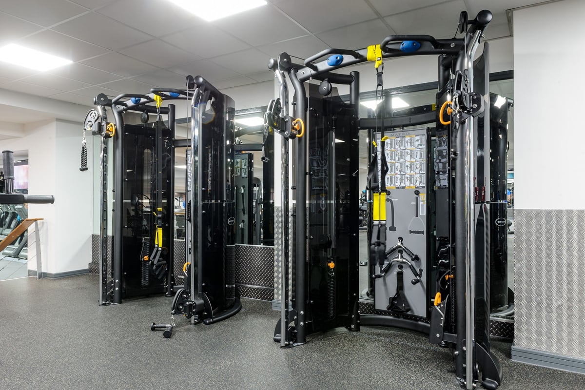 PureGym Billericay: Rows of functional training machines, cable columns, and yellow accents in a gym setting.