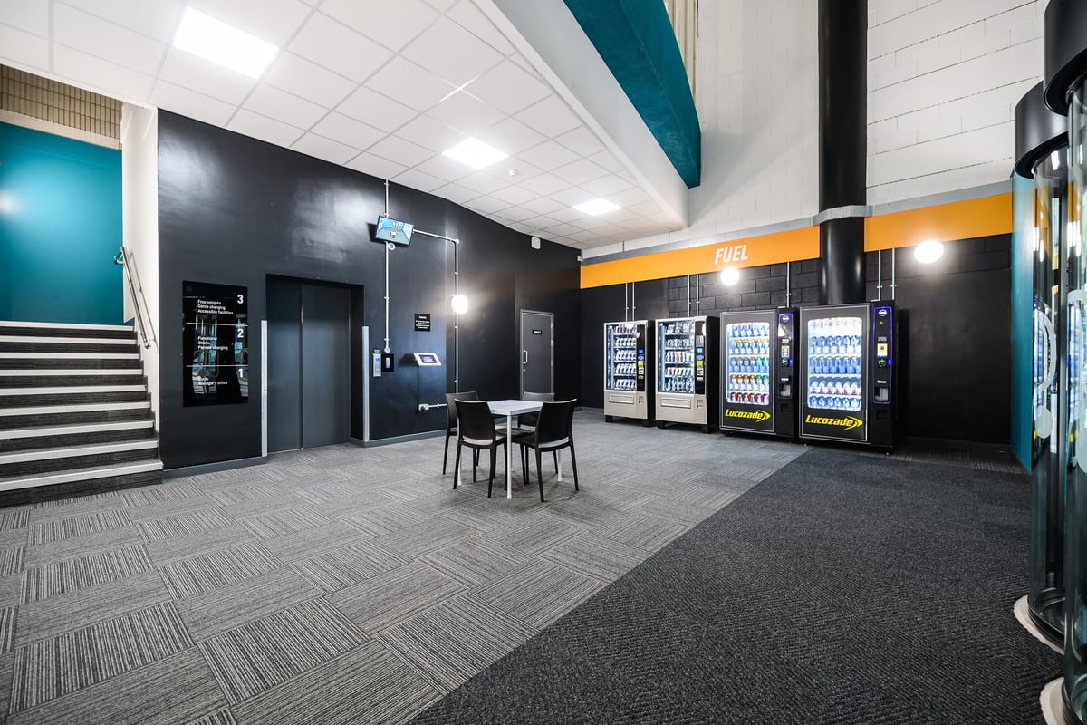 PureGym Birmingham Arcadian Centre: Spacious entry area with table and chairs and food and beverage vending machines.