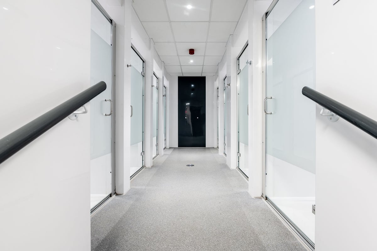 PureGym Manchester Spinningfields: Fully enclosed shower stalls with frosted glass doors.