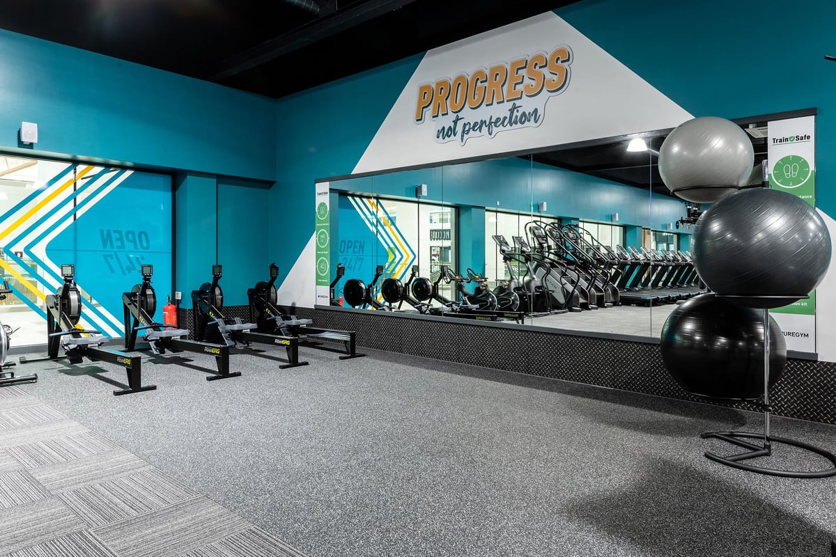 PureGym Bracknell: Progress strength and conditioning area with weight benches, medicine balls, and rubberized flooring.