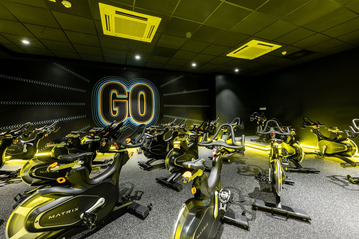 PureGym Purley: Rows of stationary cycles in yellow and black color scheme with 'GO' branding.
