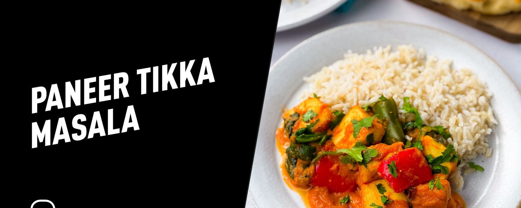 Plate of paneer tikka masala with rice and naan bread in the background
