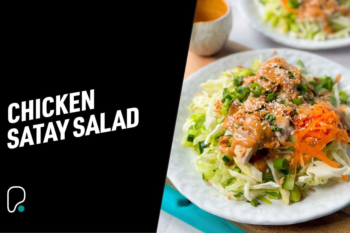 Chicken satay salad with shredded cabbage, carrot, green onions, and sesame seeds
