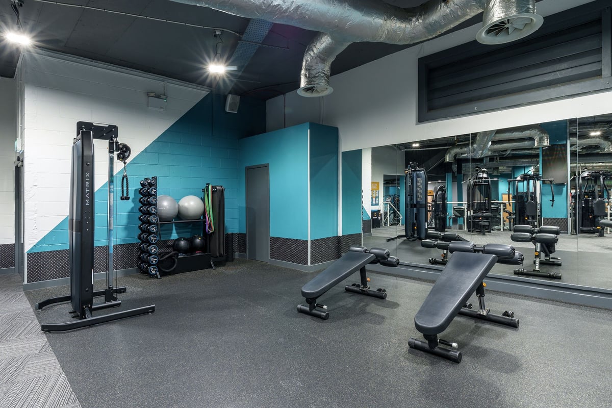 PureGym Leeds City Centre South stretch area with functional equipment and benches