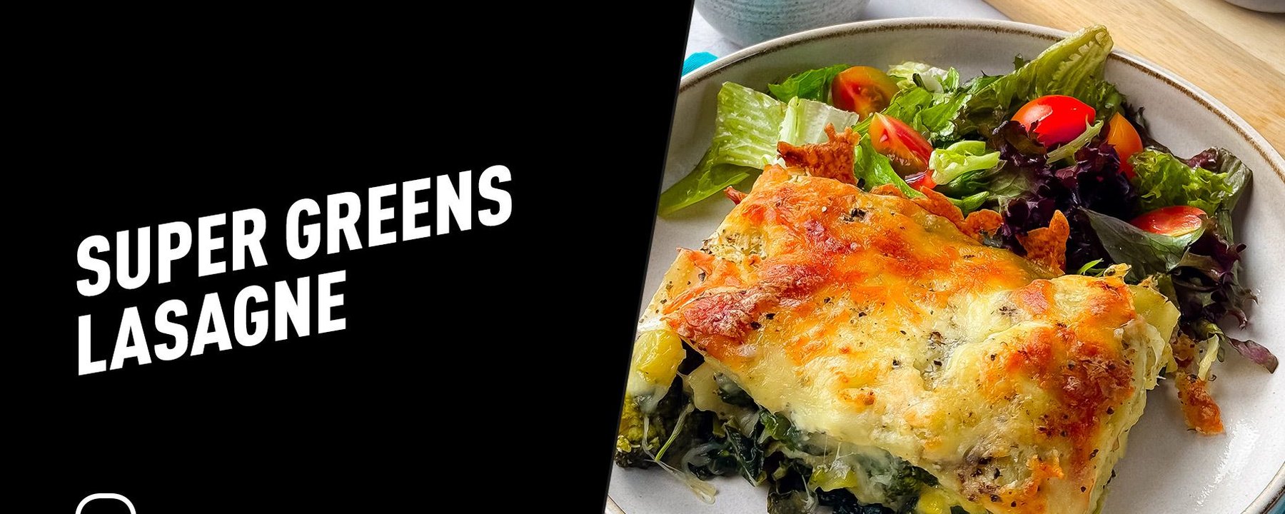 Baked super greens lasagne slice with mixed salad and grated cheese in bowl