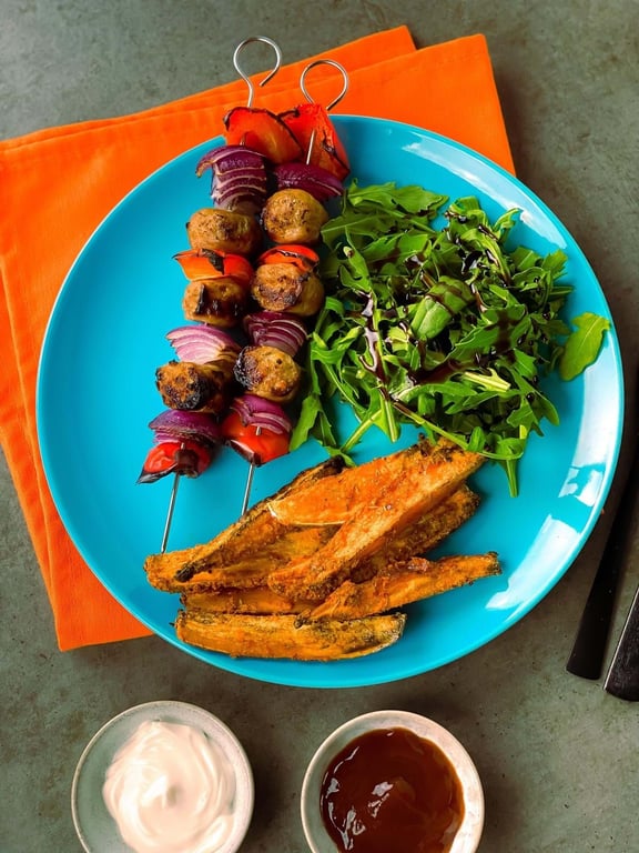 Grilled vegetable skewers, sweet potato fries, rocket salad with balsamic glaze, and dips.