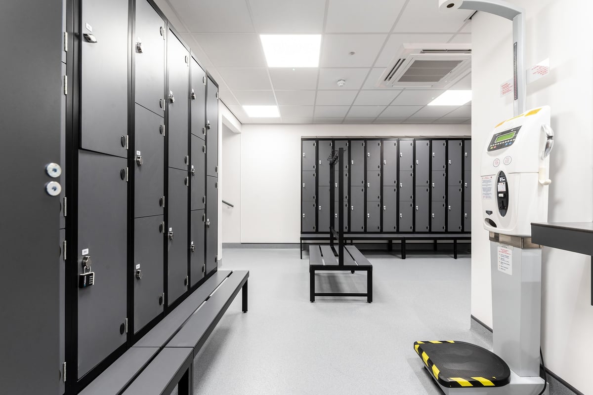 PureGym Chippenham: Locker room with rows of lockers, benches, and storage cubbies.