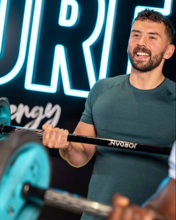PureGym member holding a barbell, taking part in a Pump class 