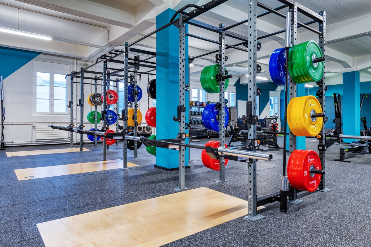 Gym Olten Squat-Rack-Bereich mit bunten Olympia-Scheiben und Hebeplattformen