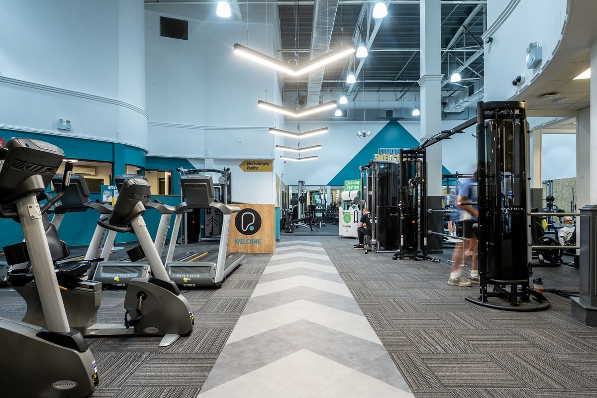 PureGym Rochdale: Gym with treadmills, weight machines, rubberized flooring, and industrial-style lighting fixtures.