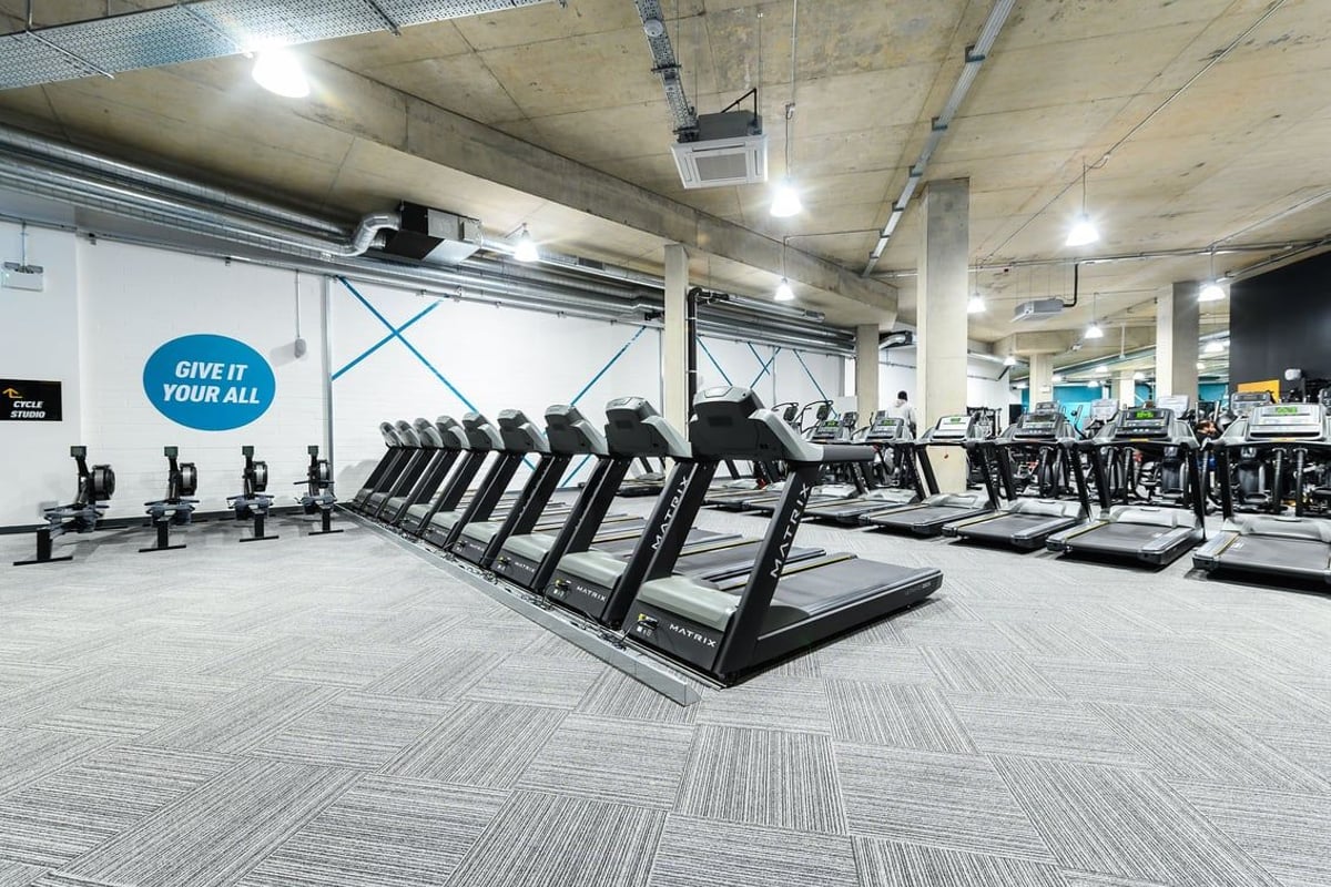 PureGym London Kidbrooke Village: Rows of treadmills, exercise bikes, and stair climbers in a brightly lit gym area.