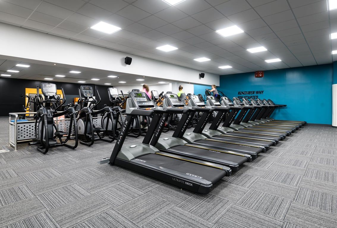 PureGym Aylesbury: Rows of treadmills, stationary bikes, and cross-trainers in a brightly lit fitness space.