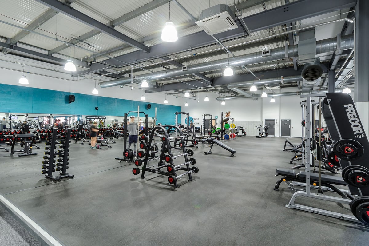 PureGym Worcester: Weight racks, dumbbell stands, exercise machines, and mirrored walls in a large gym space.