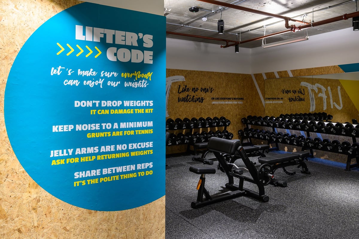 PureGym London Fulham: Weight benches, free weights, mirrors, code of conduct signage, and rubberized flooring.