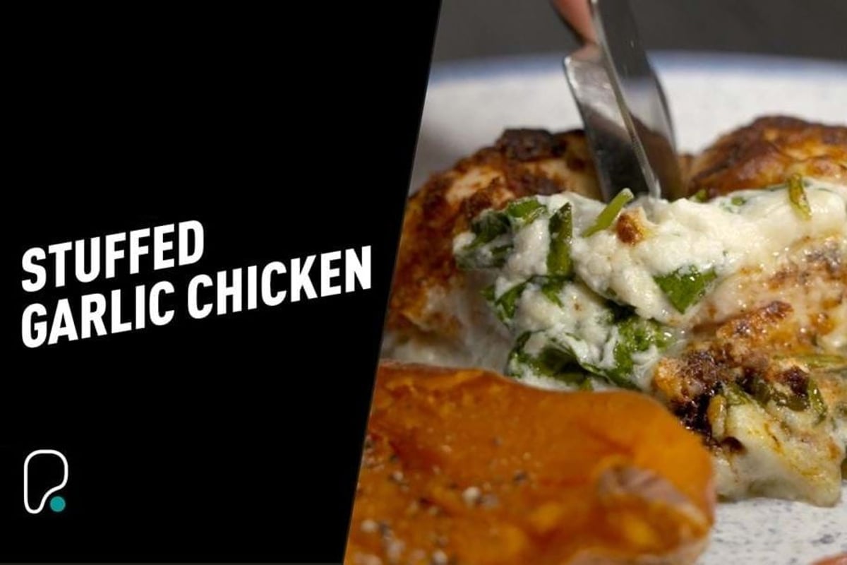 Stuffed chicken breast with melted cheese being lifted with a fork
