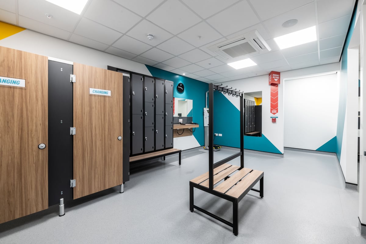 PureGym London Kingston: Lockers, benches, and walking path inside a changing room facility.