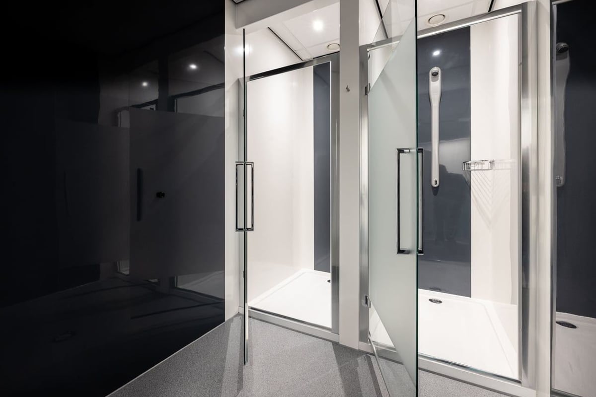 PureGym Washington: Shower cubicles with glass doors, tiled walls and floors.
