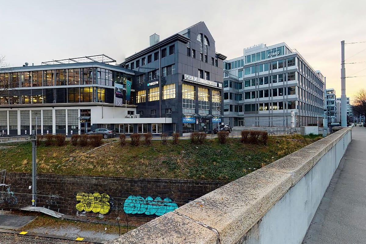 PureGym Zürich Lochergut: Bâtiments modernes dotés de la signalétique PUREGYM.