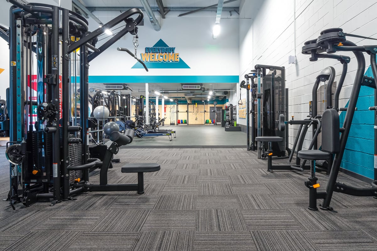 PureGym Linlithgow: Resistance machines, cable crossover stations, benches, free weights on racks, and rubberized flooring.