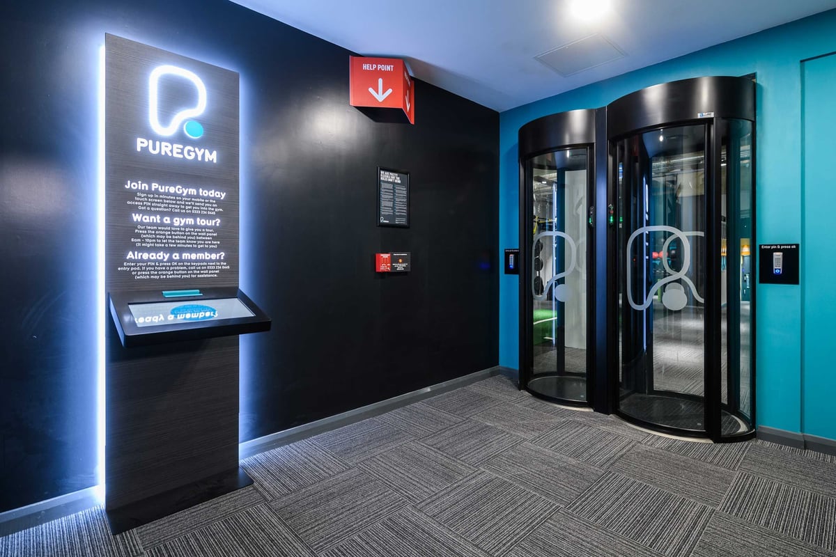 PureGym London Farringdon: Gym entrance with help point self-service registration kiosk.
