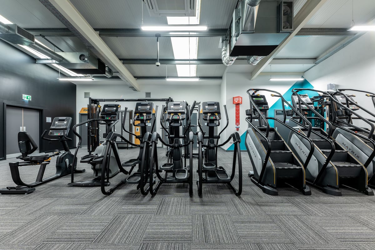 PureGym Maidenhead: Rows of elliptical trainers, treadmills, and exercise bikes in a modern fitness centre.