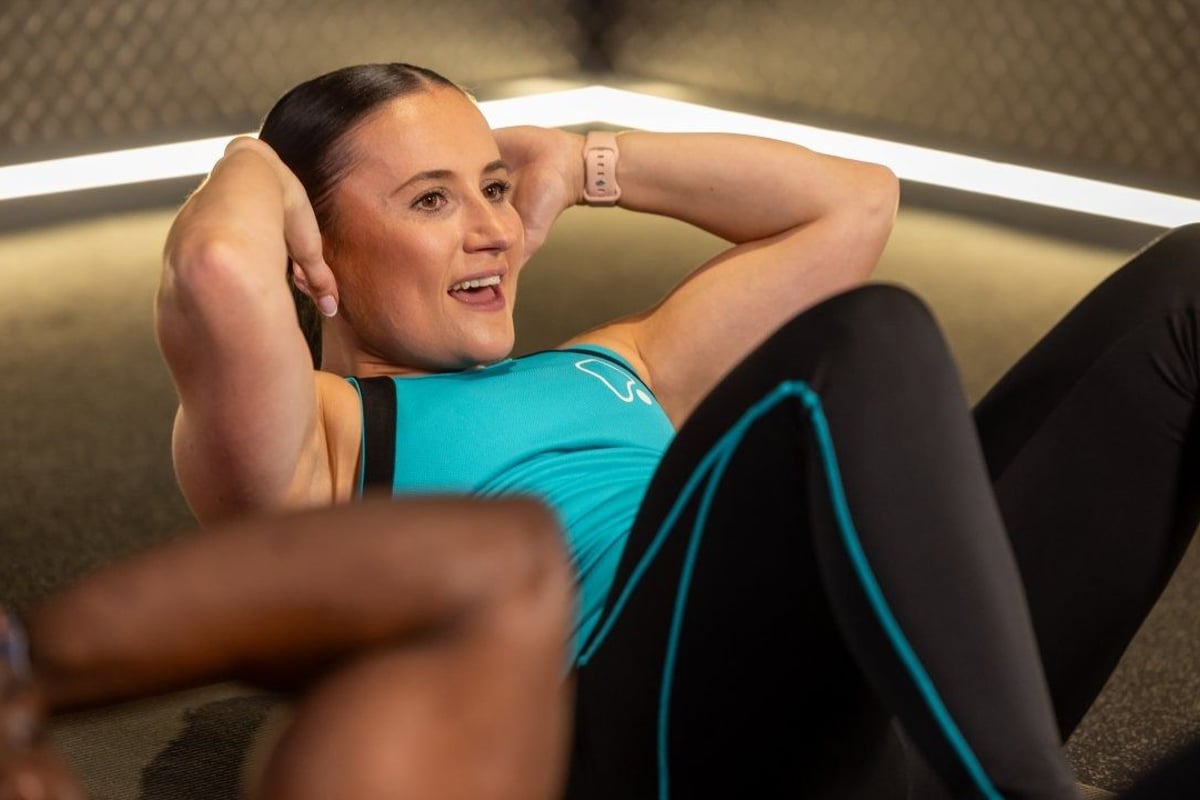Female fitness coach performing sit up class