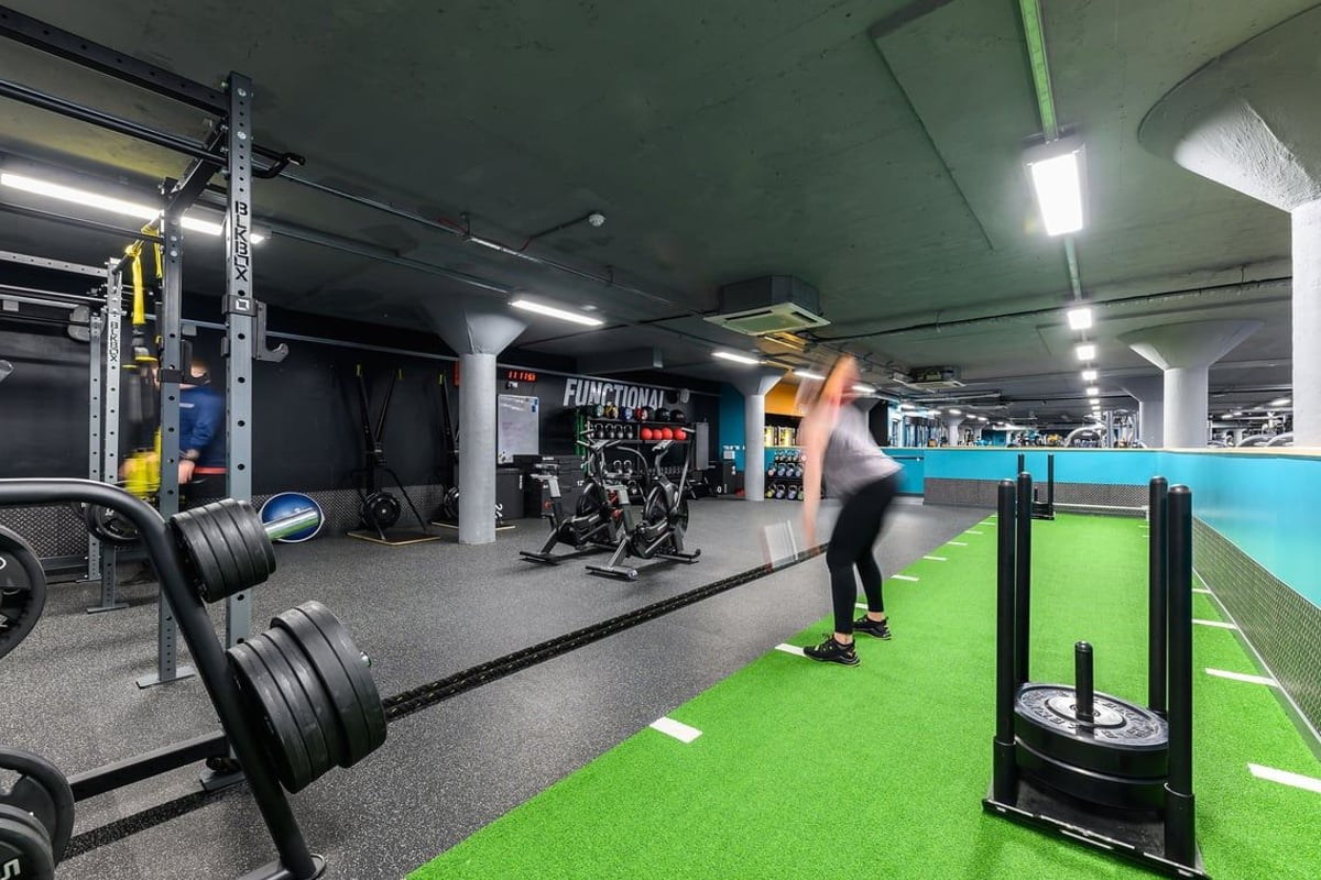 PureGym Nottingham Basford: Weight racks, free weights, turf area for functional training, mirrors along walls.