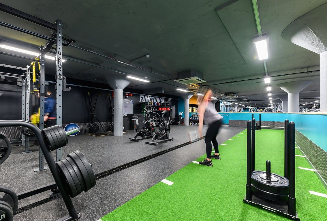 PureGym Nottingham Basford: Weight racks, free weights, turf area for functional training, mirrors along walls.