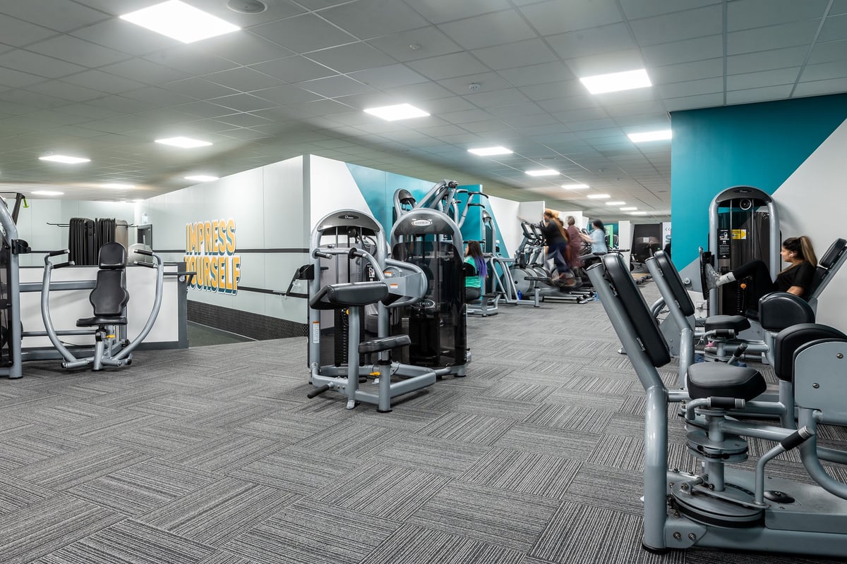 PureGym Birmingham Beaufort Park: Resistance machines, free weights, benches and mirrored walls in a gym studio setting.