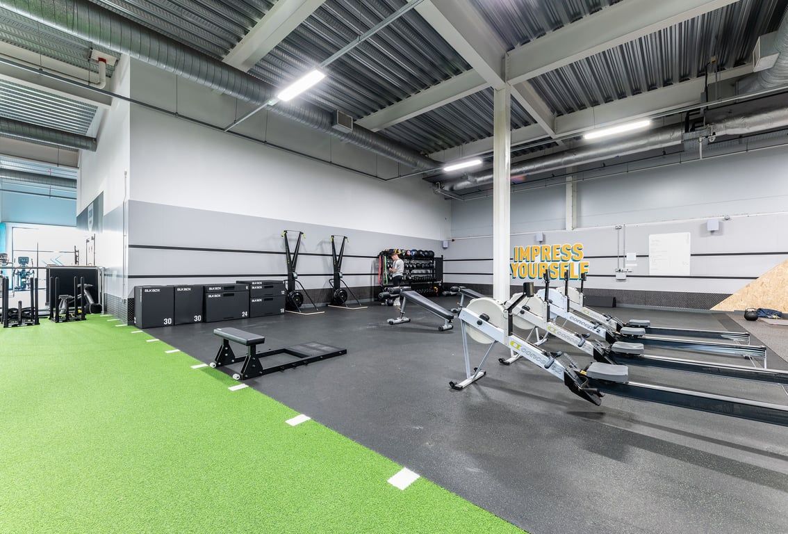 PureGym Hednesford Cannock: Gym floor with weightlifting platforms, squat racks, bumper plates, and turf area.