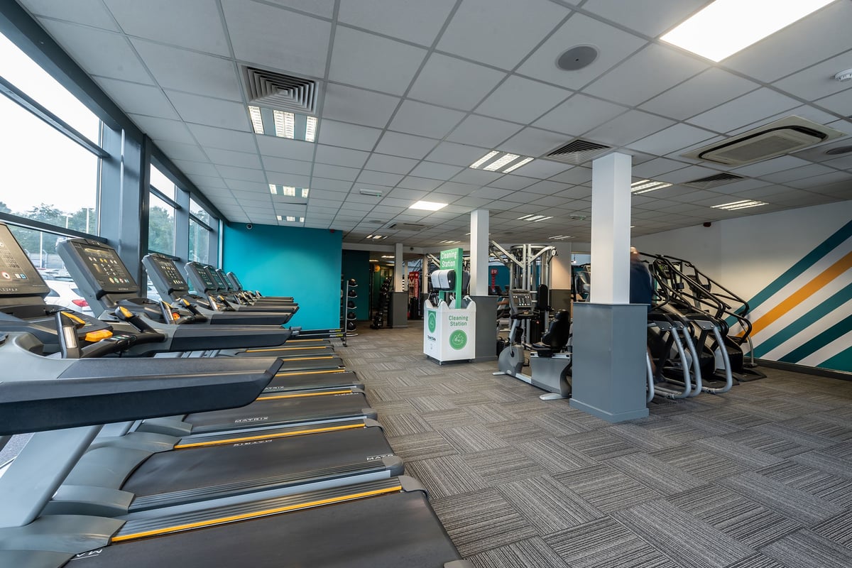 PureGym Rochdale: Rows of treadmills, weight machines, benches, and mirrored walls in a bright gym interior.