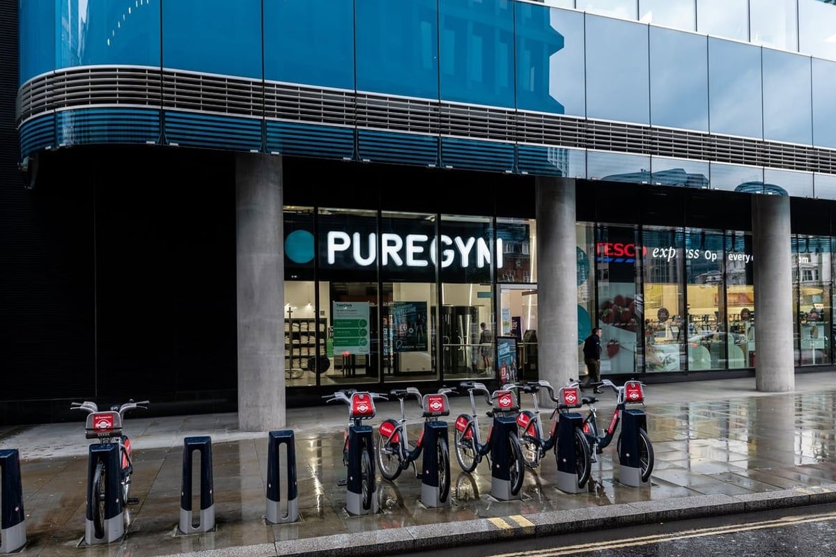 PureGym London Aldgate: Exterior of gym with rental cycles, automated cycle stations near entrance.