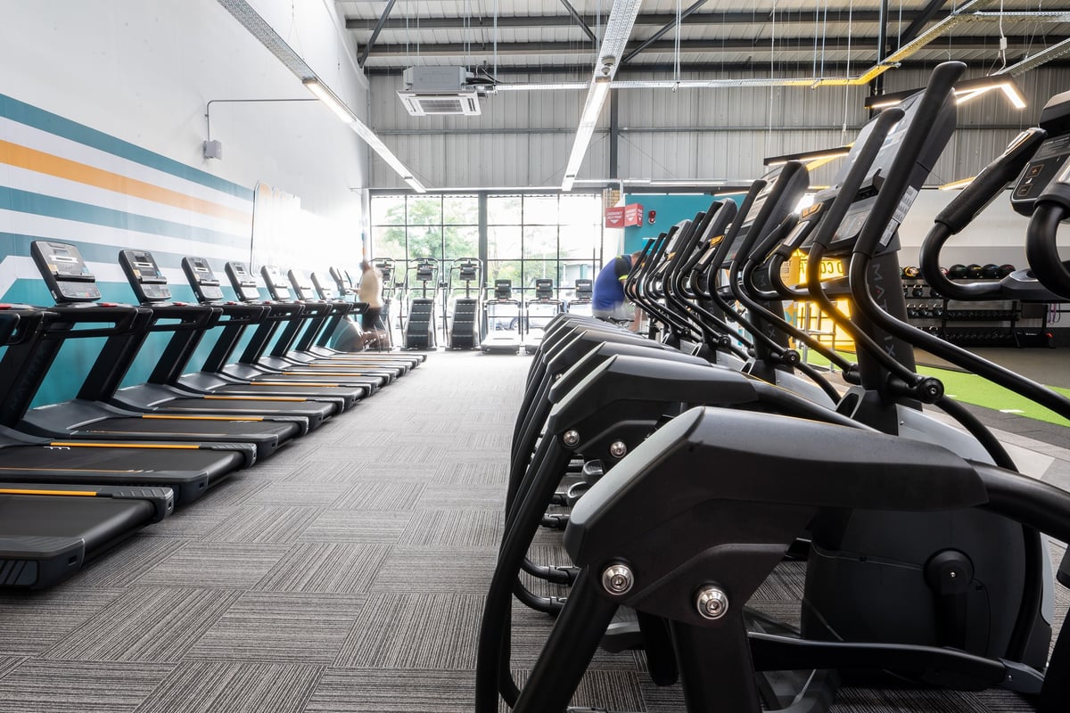PureGym Dover: Rows of treadmills and elliptical trainers in a well-lit gym studio.