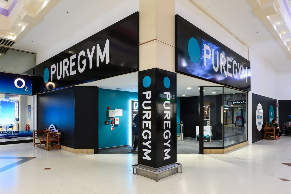 PureGym Northampton Weston Favell: PureGym signage, kiosks displaying the brand logo and colours of blue and black.