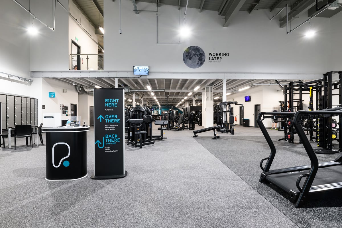 PureGym Aberdeen Wellington Circle: Weight machines, treadmills, free weights, and mirrored walls in a modern gym interior.