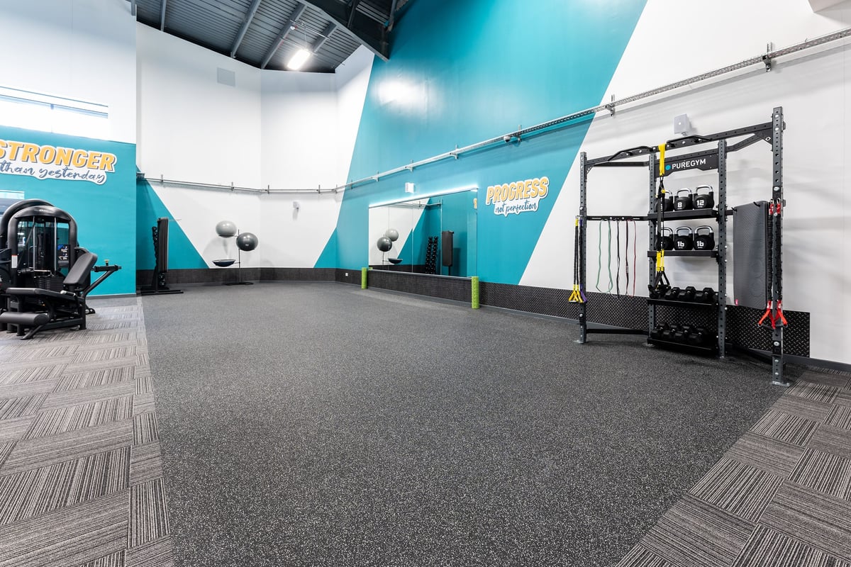 PureGym Sevenoaks: Functional training area with pullup rig, heavy bags, rubberized flooring in teal and green colour scheme.