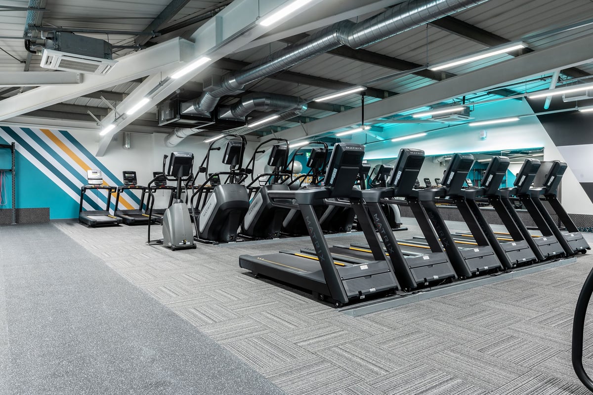 PureGym Milton Keynes Kingston Centre: Rows of treadmills lined up in a modern gym studio with accent lighting.
