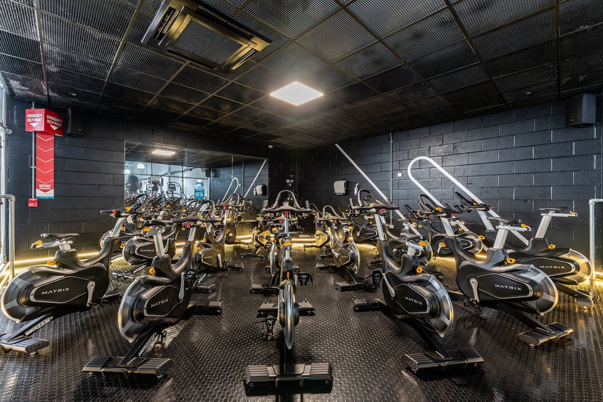 PureGym Wolverhampton Bentley Bridge: Rows of stationary exercise bikes in a dimly lit fitness studio.